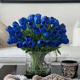 Arrangement of blue tulips in a large cylindrical vase